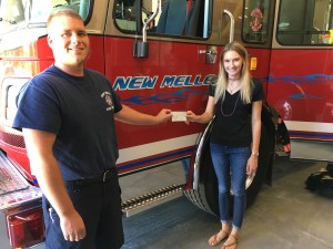 NMFR Firefighter Josh Ellis presents check to Delaney Schmidt